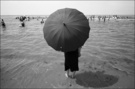 黑衣黑伞站在水里（海边溜号的人） 